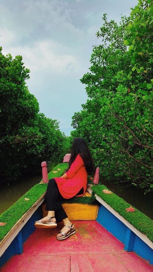 photo of me sitting at the apex of a boat, looking at the greenery in between the lake