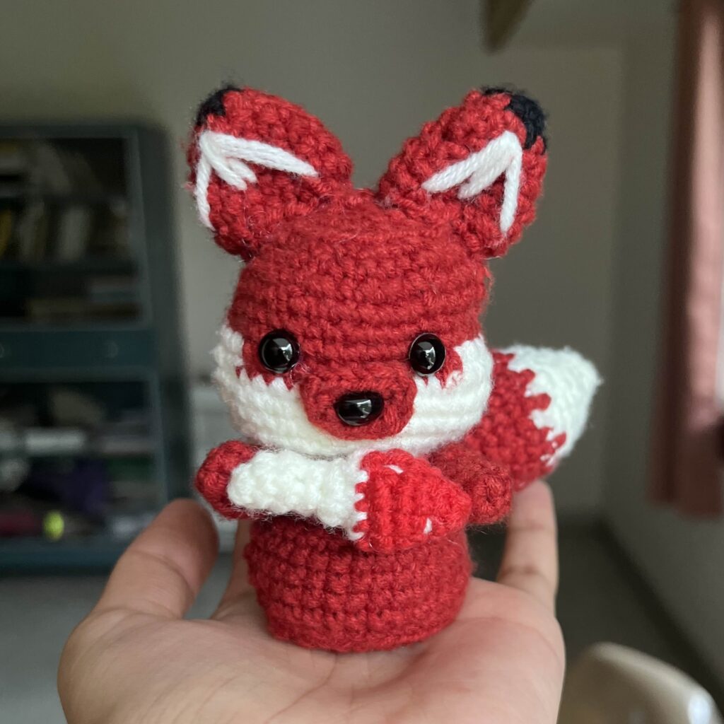 fox holding a mushroom crochet doll