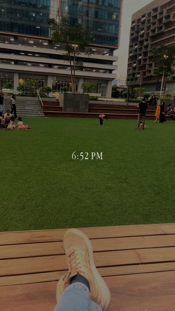 snap showing 6:52 PM on top of a photo of a green field surrounded by stairs where people are mingling and chilling
