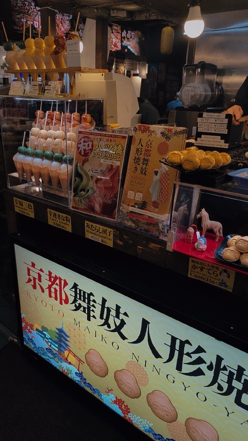 a street food stand with mitarashi and sponge cakes