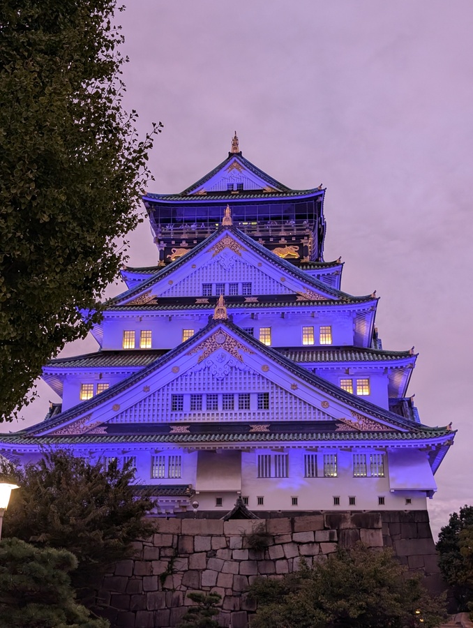 osaka castle with lights on during sunset